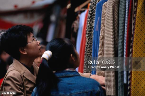 people shopping for clothes in the xiushui silk market in the jianguomenwai embassy area in beijing. - jianguomenwai stock-fotos und bilder