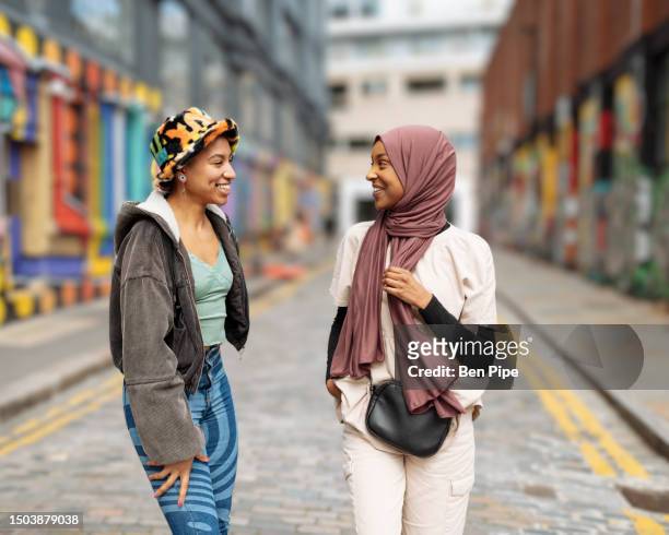portrait of young women laughing on city street - style stock pictures, royalty-free photos & images