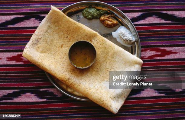masala dosa - a south indian pancake made from a lentil flour and water batter and stuffed with mashed potato and spices - dosa imagens e fotografias de stock