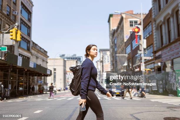 asian female student navigating soho and west village with mobile phone - west asian ethnicity stockfoto's en -beelden