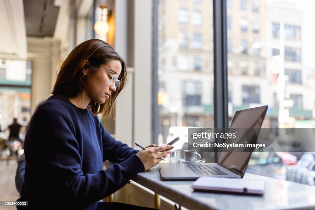 Learning in the Heart of Soho: Asian Female Student Engaged in Laptop Study Session