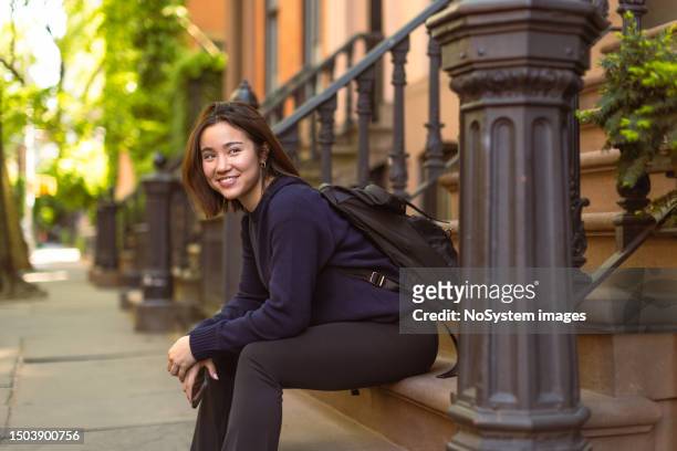 asian student finds solitude on a west village doorway in nyc - dedication brick stock pictures, royalty-free photos & images