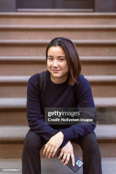 asian student finds solitude on a west village doorway in nyc - dedication brick stock pictures, royalty-free photos & images