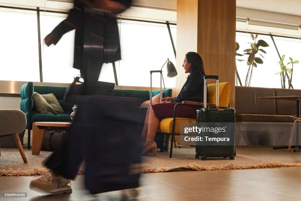 ダイナミックな空港シーン:VIPラウンジのビジネスマン、機内持ち込み手荷物を持つ旅行者のぼかした動き。