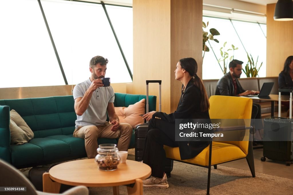 Fachlicher Austausch: Geschäftsreisende tauschen sich in einem Flughafencafé aus.