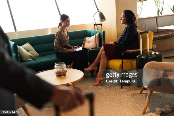 elevated collaboration: businesswomen engaged in discussion in airport vip lounge - airport business lounge stock pictures, royalty-free photos & images