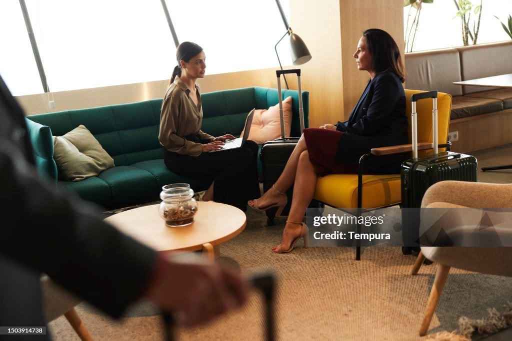 Elevated Collaboration: Businesswomen Engaged in Discussion in Airport VIP Lounge