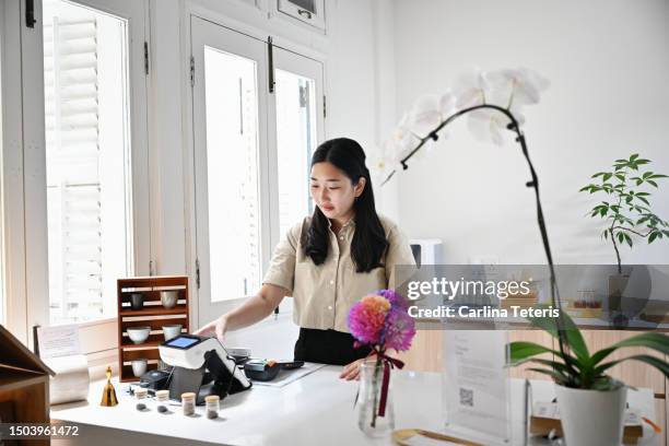 employee setting on pos in a cafe - pos system stock pictures, royalty-free photos & images