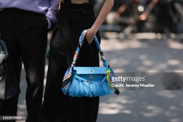 Kiwi Lee is seen wearing a feather blue leather Hermes bag with a scarf, black suit wide leg pants and Jun Chiu is seen wearing a black Hermes Kelly...