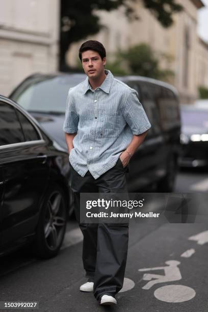 Blake Grey is wearing a blue button shirt with short sleeves and black pants with white sneakers outside Amiri Show during the Menswear Spring/Summer...