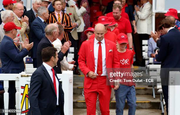 Andrew Strauss and families supported by the Ruth Strauss Foundation after losing a partner and/or parent to cancer enter the field of play to help...