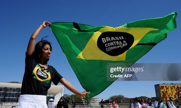 Demonstrator holds a Brazilian flag during a protest in front of the Supreme Court, where the trial known as 'mensalao' is being held, in Brasilia,...