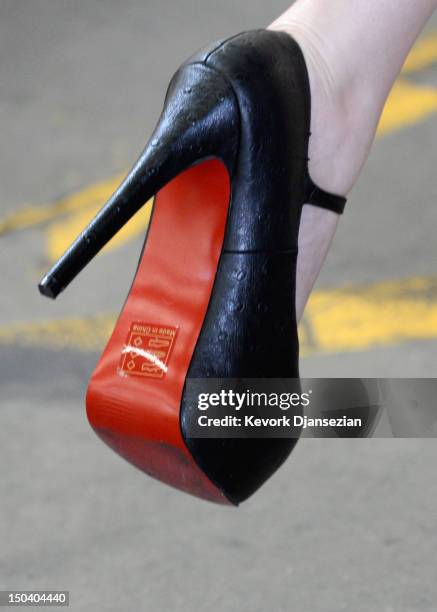 Inside-Edition television reporter Brianna Deutsch puts on a pair of counterfeit Louboutin pumps and high heels featuring the distinctive red sole of...