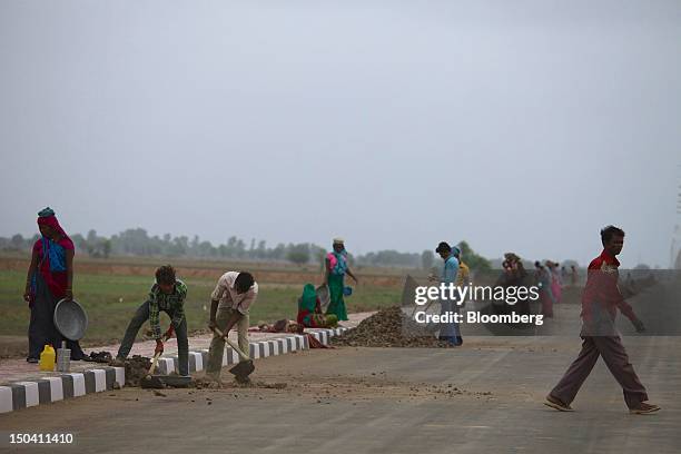 Laborers construct a road in Sanand, Gujarat, India, on Wednesday, Aug. 8, 2012. India’s growth slowed to 5.3 percent in the three months through...