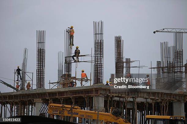Laborers work on a factory construction site in Sanand, Gujarat, India, on Wednesday, Aug. 8, 2012. India’s growth slowed to 5.3 percent in the three...