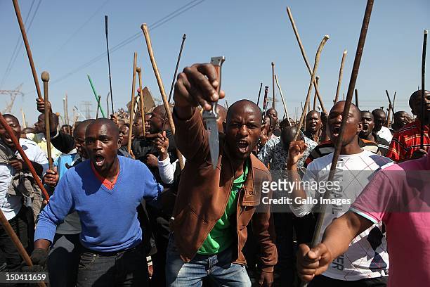 Striking mine workers demonstrate as they protest over wage demands outside the Nkageng informal settlement on August 16, 2012 in North West, South...