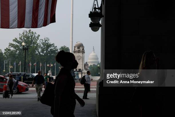 Woman wears a face mask to protect against air pollution as she walks through Union Station on June 29, 2023 in Washington, DC. The Washington DC...