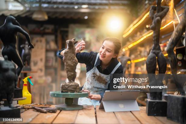 young female sculptor is working in her studio - mobile sculpture fotografías e imágenes de stock