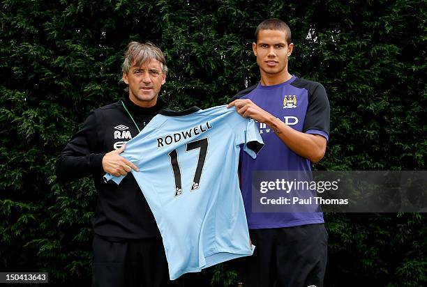 New Manchester City player Jack Rodwell and manager manager Roberto Mancini pose for a photograph at the MCFC Carrington Training Complex on August...