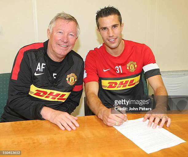Manager Sir Alex Ferguson poses with Robin van Persie as he signs for Manchester United FC at their Carrington Training Ground on August 17, 2012 in...