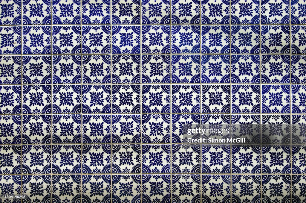 Wall of colonial-style Talavera blue and white tile featuring a pattern of circles, dots and flourishes