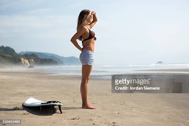 a female preparing to go surfing. - oregon amerikaanse staat stockfoto's en -beelden