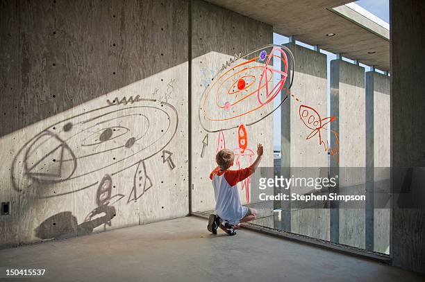 boy drawing rocket ships and planets on window - kids drawing stock-fotos und bilder
