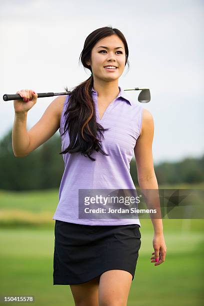 a female playing a round of golf. - women's golf stockfoto's en -beelden