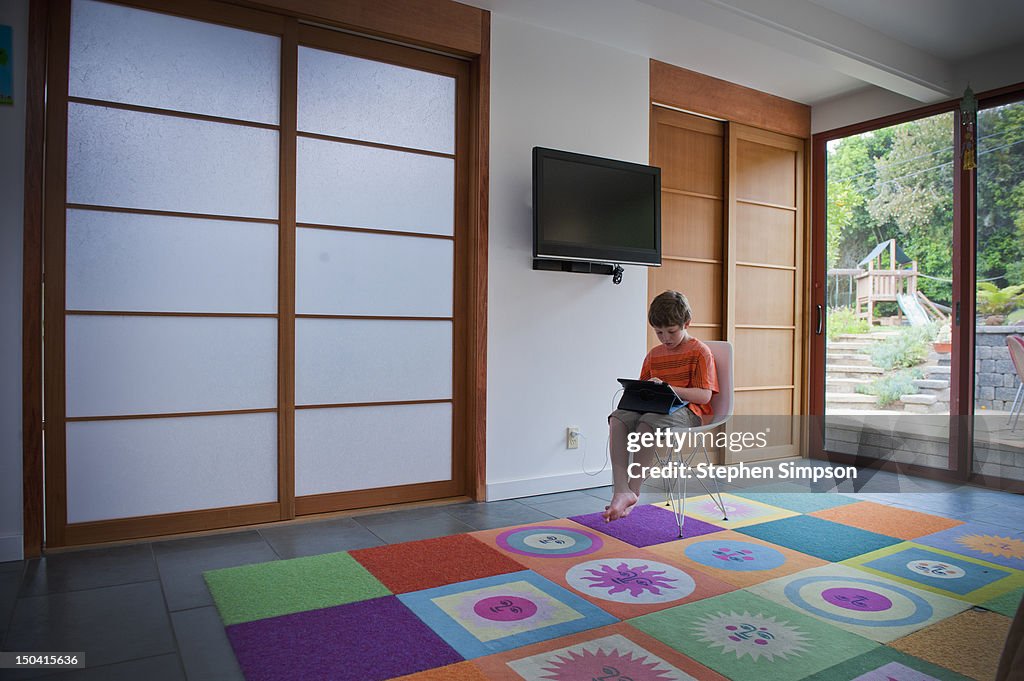 Boy, 7, alone with laptop in a large room