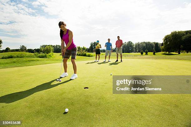 four friends golfing together. - putt - fotografias e filmes do acervo