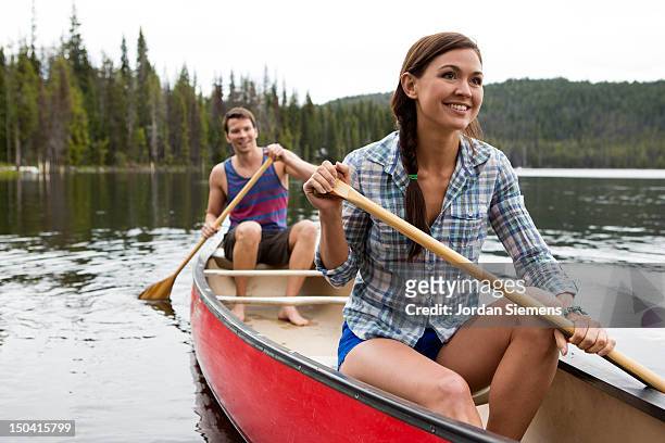 two people canoeing on a lake. - bent stock pictures, royalty-free photos & images