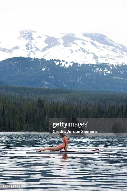 woman stand up paddle boarding. - mt bachelor stock pictures, royalty-free photos & images