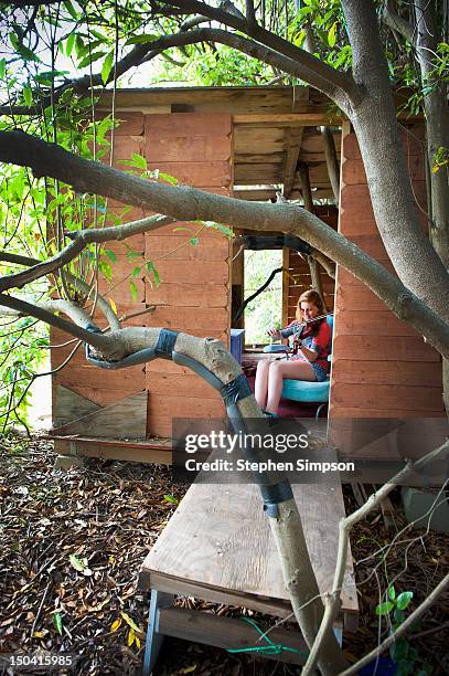 girl [11] practicing violin in her clubhouse - kids clubhouse stock pictures, royalty-free photos & images