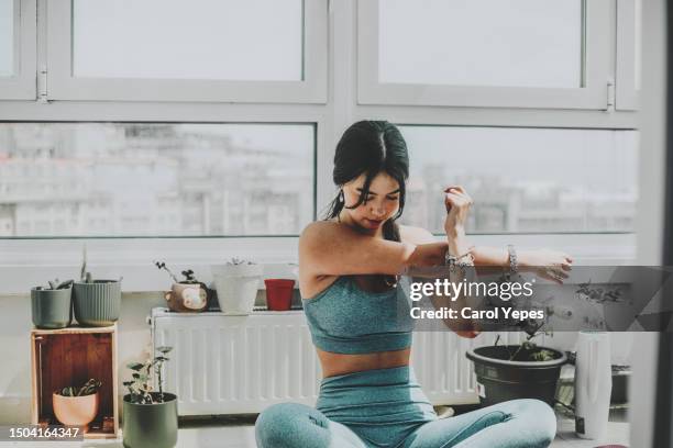 a woman performs a roll-down stretching exercise on a mat - lower back stock pictures, royalty-free photos & images