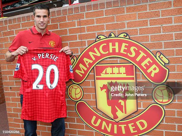 Robin van Persie of Manchester United poses with a Manchester United shirt after signing a four year contract with the club at Old Trafford on August...
