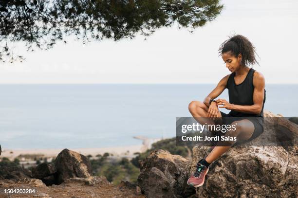 runner checking fitness progress on her smartwatch - fitness tracker stock pictures, royalty-free photos & images