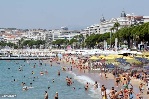 People are pictured on the beach in the French southeastern city of Cannes on August 15, 2012. AFP PHOTO / JEAN CHRISTOPHE MAGNENET