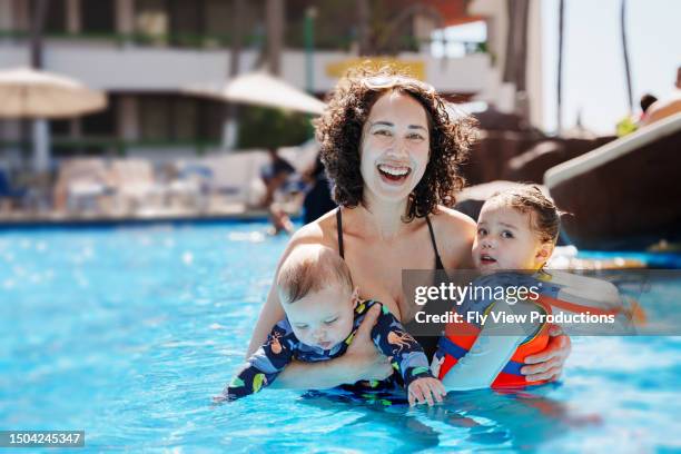 portrait of mother and two children in a pool - mexican asian babies stock pictures, royalty-free photos & images