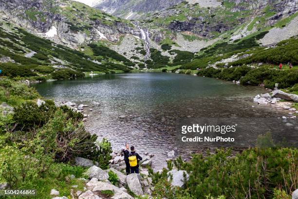 Tourists are seen by the Velicke Pleso lake in Tatra mountains in Slovakia on July 5, 2023. Slovakia, a mountainous country, is a popular tourist...