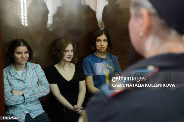 Members of the all-girl punk band "Pussy Riot" Nadezhda Tolokonnikova , Maria Alyokhina and Yekaterina Samutsevich sit in a glass-walled cage during...