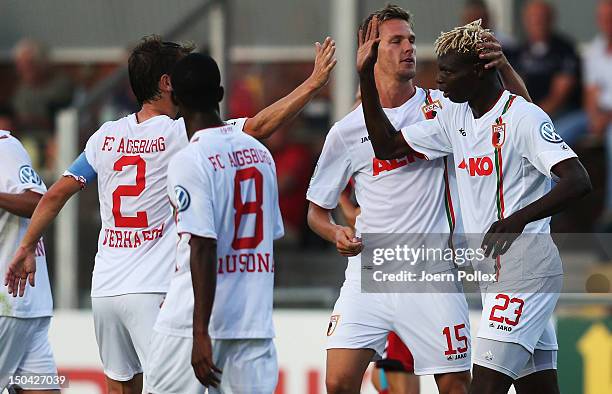 Aristide Bance of Augsburg celebrates with his team mates after scoring his team's first goal during the DFB Cup first round match between SV...