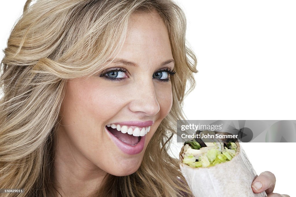Cheerful woman eating a sandwich