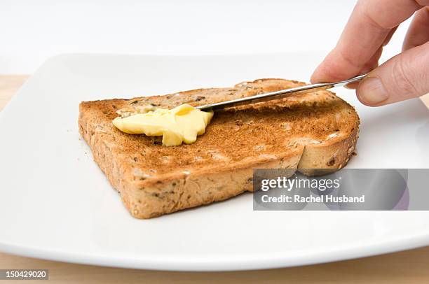 hand buttering a piece of granary toast - buttering stock pictures, royalty-free photos & images