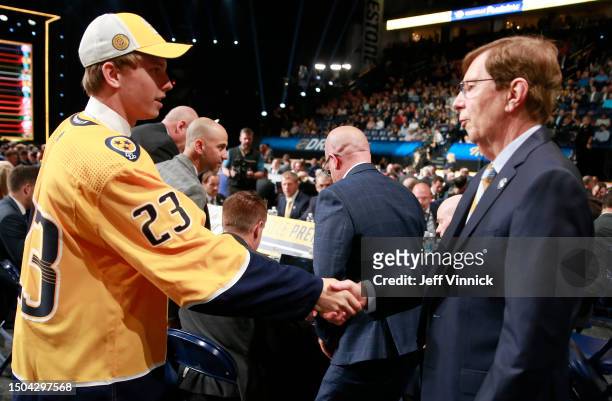 Felix Nilsson shakes hands with David Poile after being selected 43rd overall by the Nashville Predators during the 2023 Upper Deck NHL Draft -...