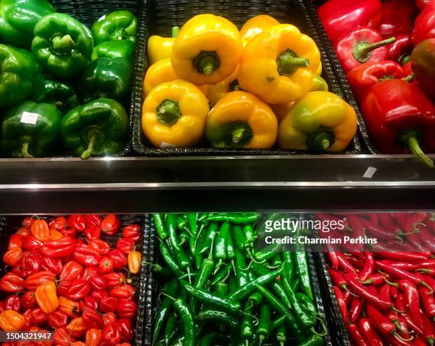 vibrant fresh organic vegetables in grocery store. bell peppers, red and green chillis, capsicums in luxury green grocer in england in march 2022 - orange bell pepper fotografías e imágenes de stock