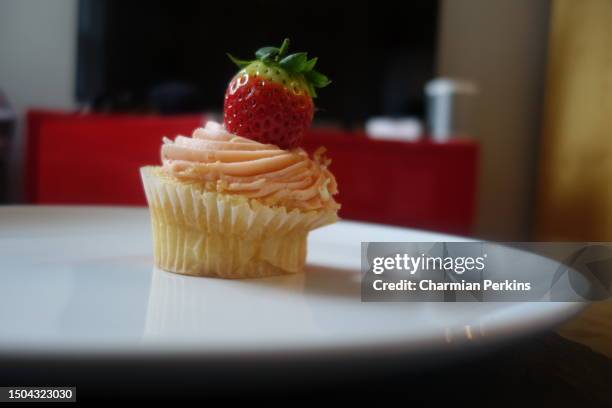 delicious organic cupcake with cream cheese frosting and fresh organic fruit topping. indulgent sweet treat. homemade gourmet cake snack in england in march 2022 - banana cream cake stock pictures, royalty-free photos & images