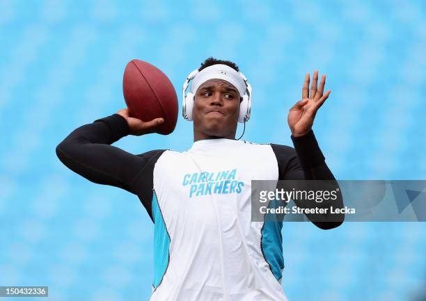 Cam Newton of the Carolina Panthers warms up before their preseason game against the Miami Dolphins at Bank of America Stadium on August 17, 2012 in...
