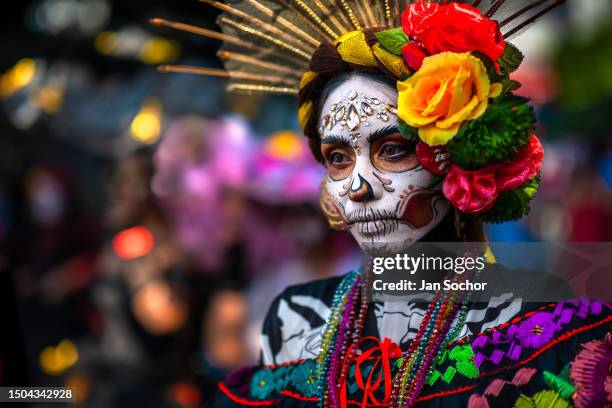 Young Mexican woman, dressed as La Catrina, a Mexican pop culture character representing the Death, takes part in the Day of the Dead festivities on...