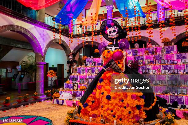 La Catrina figure is placed in front of the altar of the dead , a religious site honoring the deceased, during the Day of the Dead celebrations on...