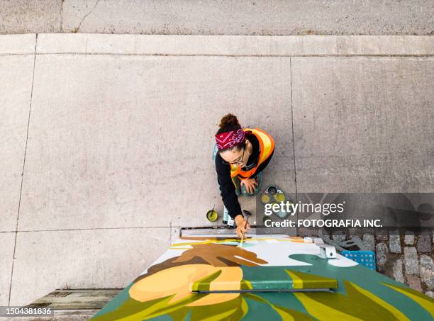 joven artista latina pintando mural de caja de acera - mural fotografías e imágenes de stock